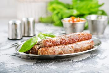 raw sausages with spice on the metal plate
