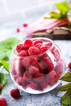 fresh raspberry in glass and on a table