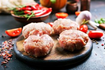 raw cutlets for burger on wooden board