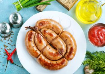 sausages on white plate and on a table