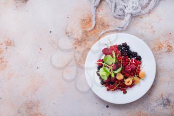 mix berries on plate and on a table