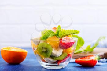 fruit salad in glass bowl and  on a table