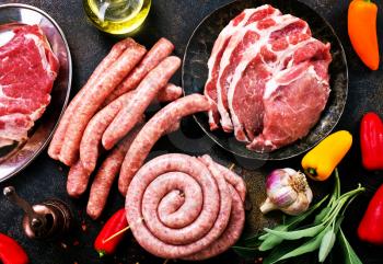 raw meat and sausages on a table, stock photo