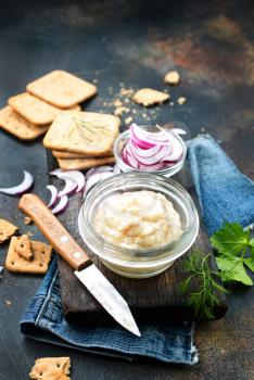 Hearty lard with garlic served with crackers on a rustic white table.