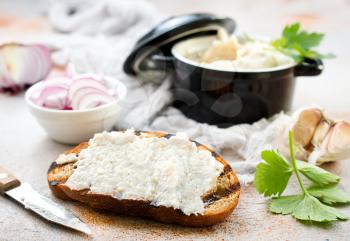 Hearty lard with garlic served with fresh bread on a rustic white table.