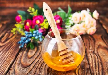 fresh honey in glass bowl and on a table