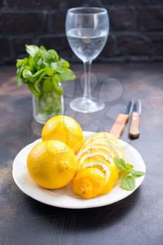 fresh lemons with mint leaves on a table