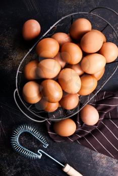 raw eggs in metal basket and on a table