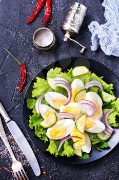 salad with boiled eggs on black plate