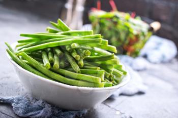 green beans in bowl and fresh leaves of mangold