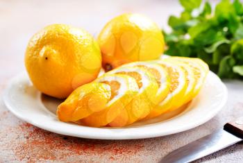 Fresh lemons and lemon slice on metal plate