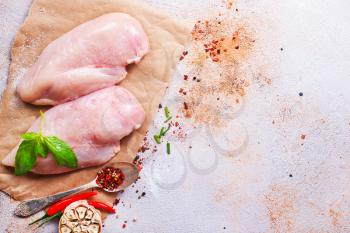 raw chicken fillet with spice and salt. chicken fillet on board, stock photo