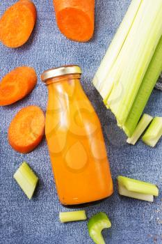 carrot smoothie with orange and cinnamon in glass jar and ingredients, detox drink