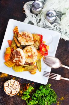 baked vegetables with cutlet on white plate