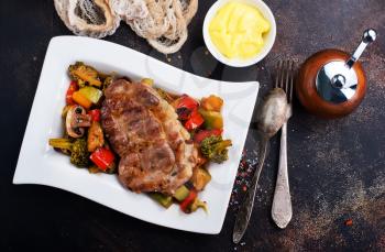 fried meat with vegetables on plate, stock photo