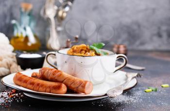 sausages with fried cabbage in bowl and on a table
