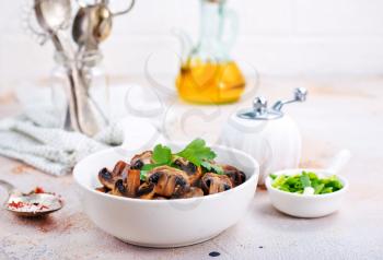  Vegan dish. Fried mushrooms and onion in the frying pan. European cuisine.