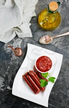 smoked sausages with tomato sauce, sausages with sauce on plate