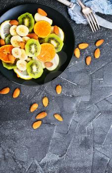 fruit salad with almond on black plate