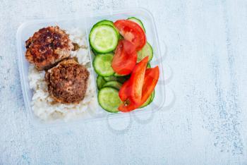 rice with cutlets and vegetables in lunchbox