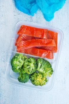 red fish with boiled broccoli, diet food in lunchbox