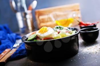 boiled eggs with vegetables in black bowl 