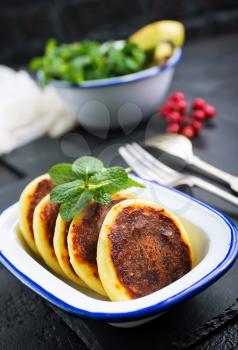 cottage cheese pancakes syrniki on plate, cheese pancakes and mint leaves