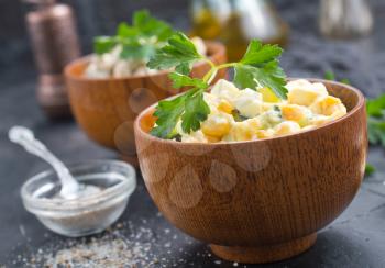 salad with corn and chicken in wooden bowl