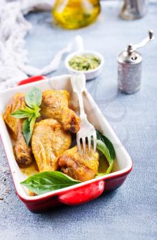 baked chicken legs with fresh basil leaves