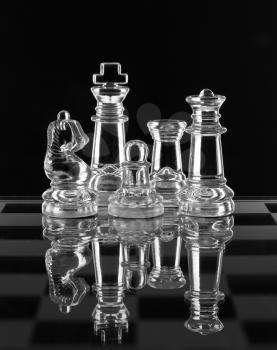 Glass chess family with reflection on black background