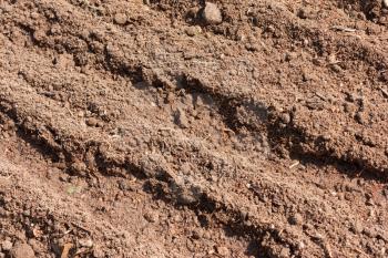 Agricultural industry concept - brown dry plowed soil surface with grooves under summer sun light, closeup view, agricultural background