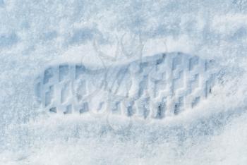 One human shoe footprint in white snow closeup view