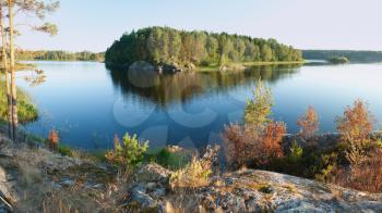 Ladoga lake with island under summer sunset light panoramic view