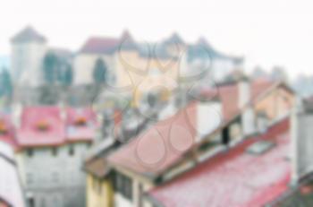 Blurred defocused urban abstract texture background of red tile roofs of houses in old city in Europe, view of vintage houses with tile roofs in old town blurred background.