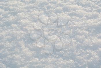 Snow surface with shiny snowflakes under bright sunlight closeup macro view with shallow DOF, winter abstract natural background