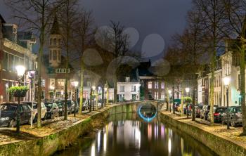 Traditional Dutch buildings along a canal in Amersfoort at night. The Netherlands