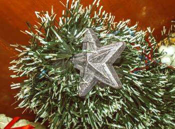 A branch of an artificial Christmas tree with silver star
