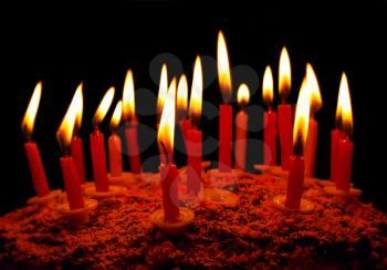 Celebratory cake with burning candles on a dark background