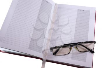 Diary and glasses isolated on white background
