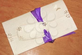 Greeting card with ribbon and sticker on the wooden background