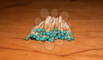 Matches with green head on a wooden background