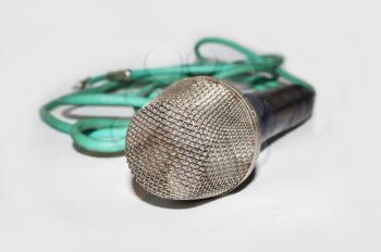 Microphone with green cable on light background