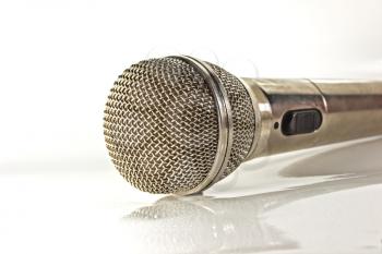 Microphone on a light background with mirror reflection