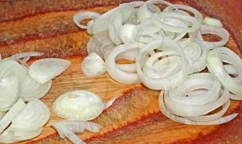 White onions sliced rings on a wooden background