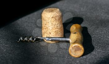 Corkscrew and cork on a contrasting background of fabric