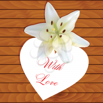 White heart with an inscription and a lily on a wooden background