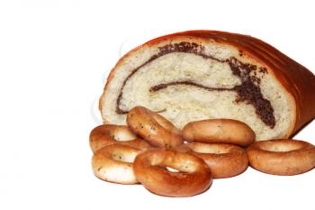 Broken roll with poppy seeds and bagels on white background