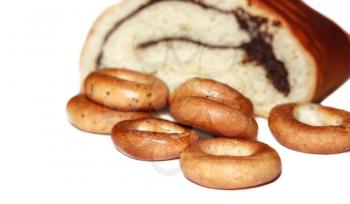 Broken roll with poppy seeds and bagels on white background