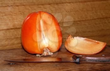 Ripe juicy persimmon on a wooden background