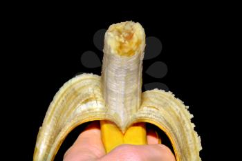 Opened banana in the hand isolated on black background